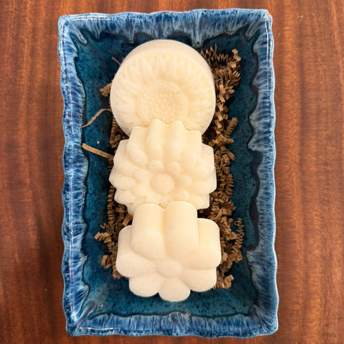 3 bars of flower shaped dish soap in blue dish