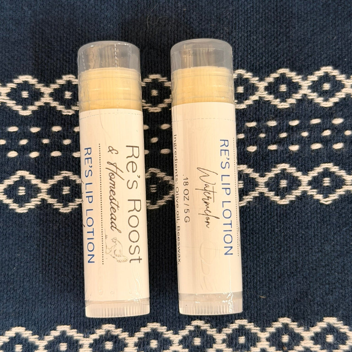 Two lip lotions on blue cloth